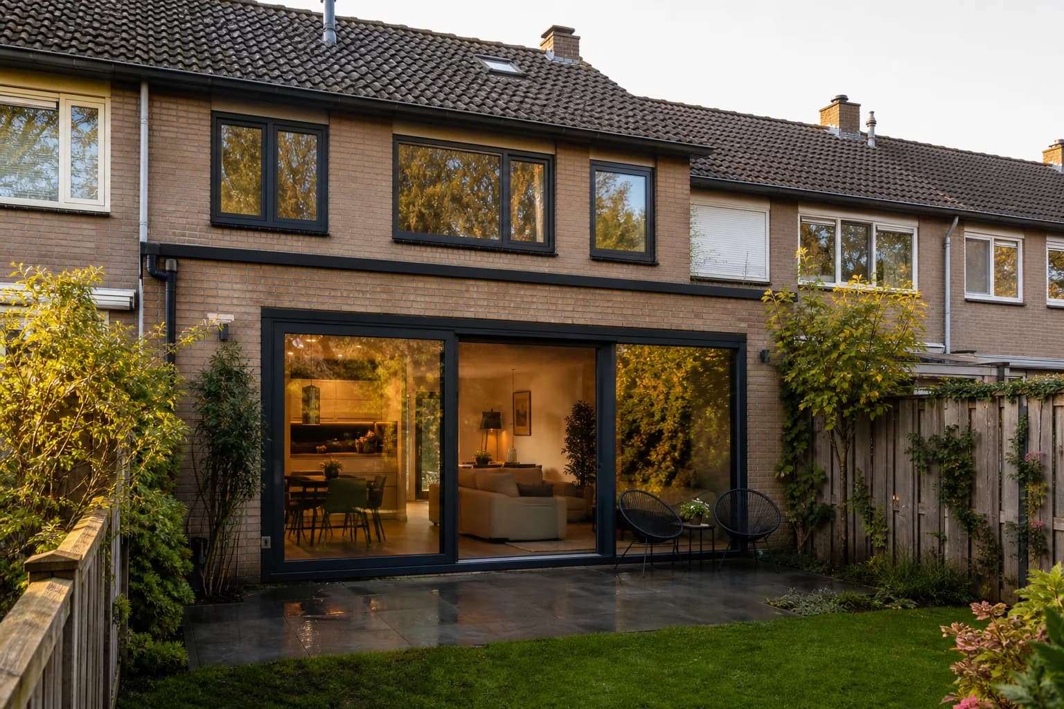 Woning met donkere kunststof kozijnen en een brede pui