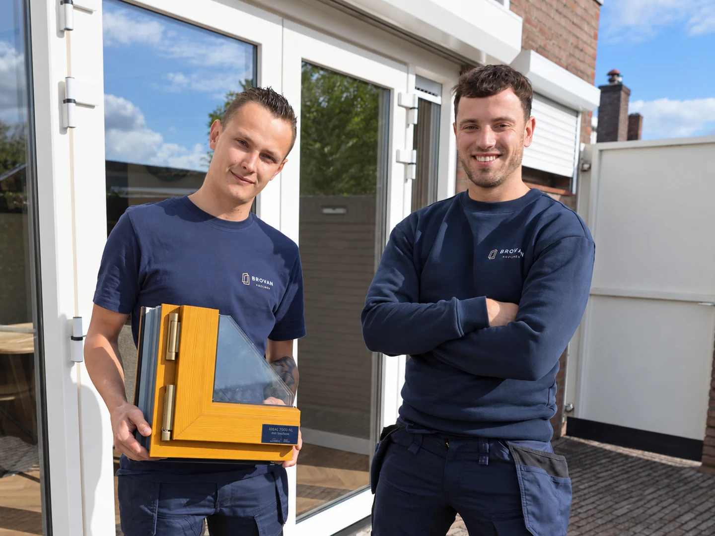 Jesse en Remy met een kozijnstaal bij een woning